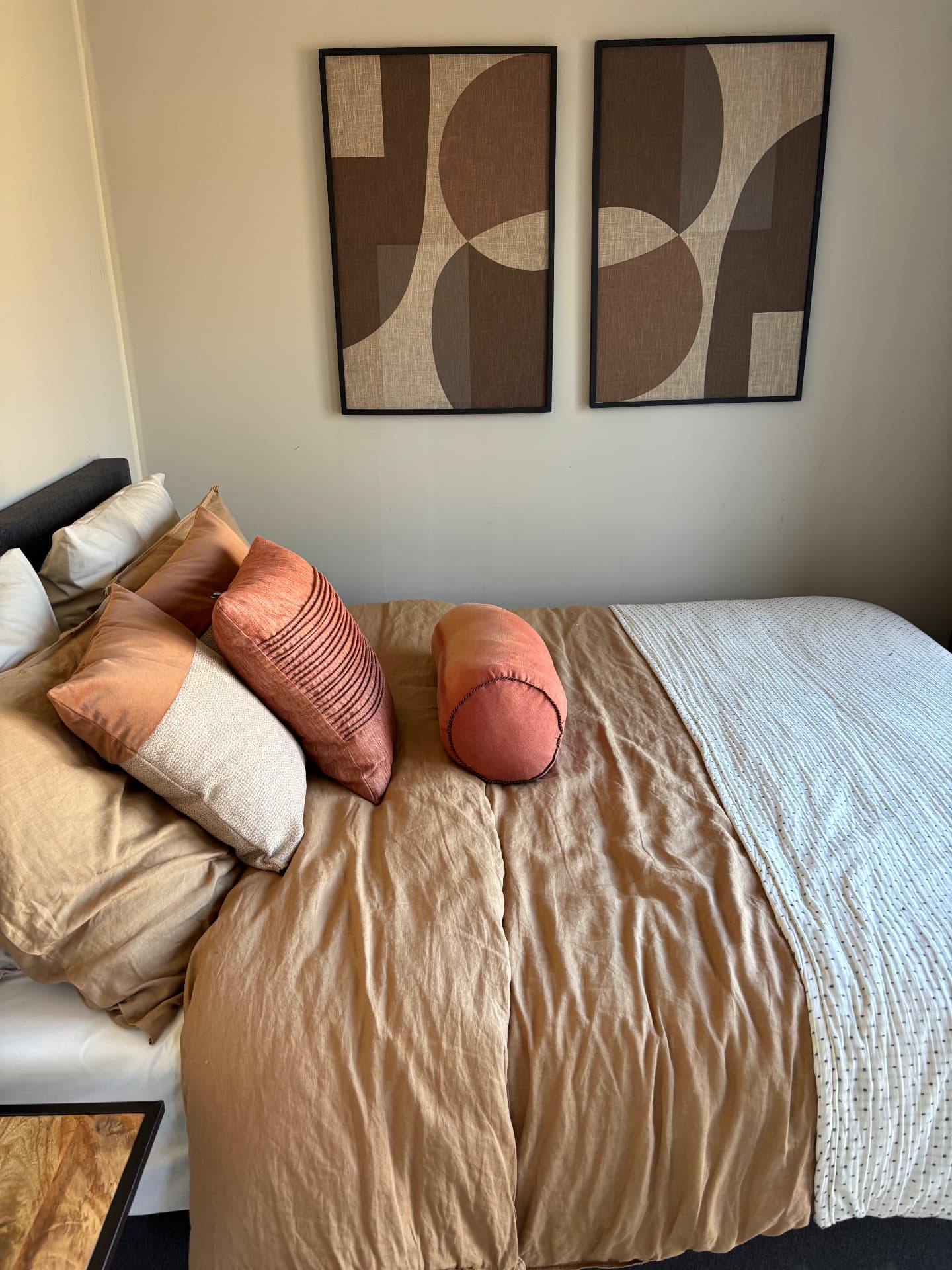 Hoofdslaapkamer in de modelwoning met warme terracotta tinten en abstracte wandkunst